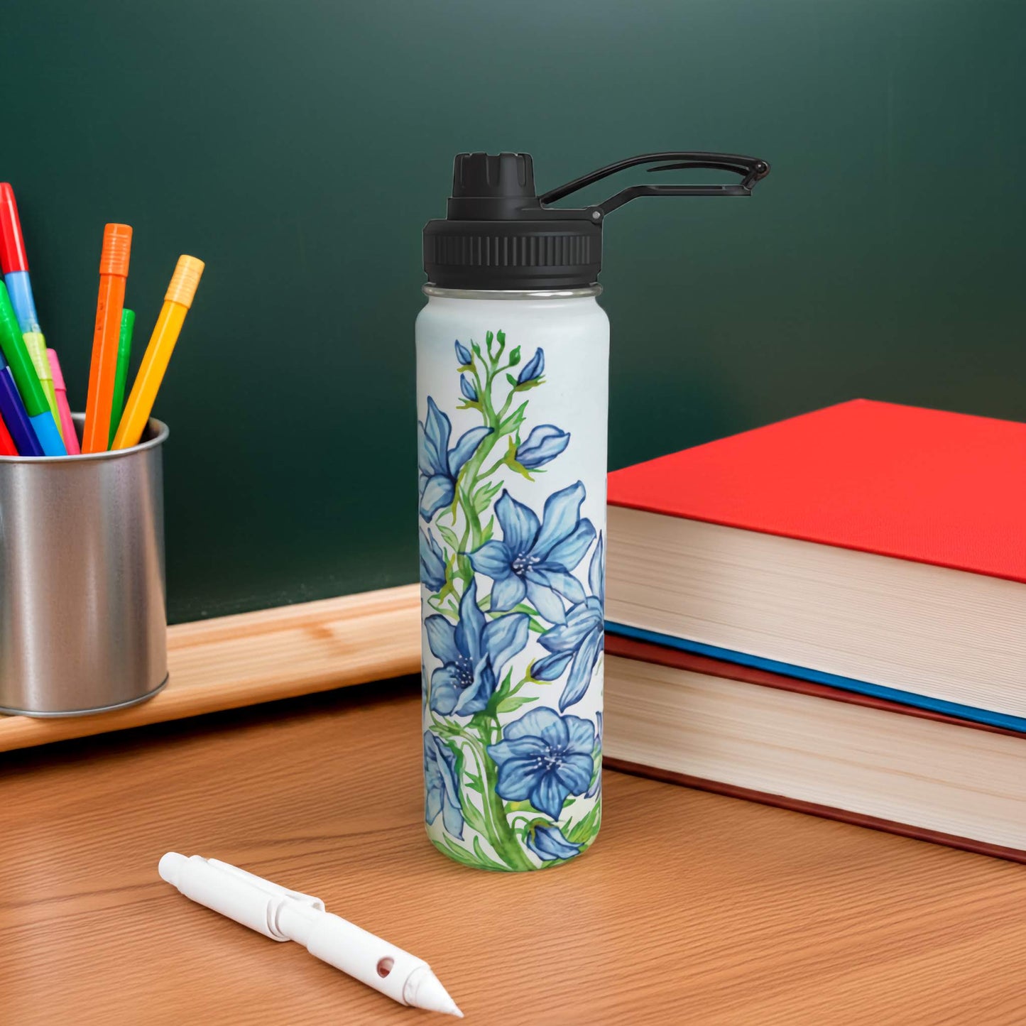Larkspur birth flower water bottle on a desk with books and markers in the background